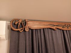 a curtain rod with a wooden handle hanging from it's side