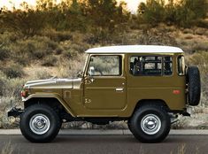 a brown jeep is parked on the side of the road