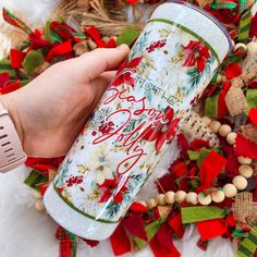 a person is holding a christmas drink in front of some wreaths and garlandes