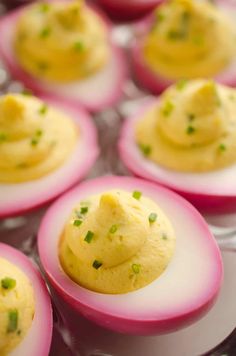 deviled eggs with chives and green onions on a plate