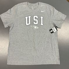 Show Your Support For The University Of Southern Indiana Eagles, Usi With This Brand New Nike Shirt. Perfect For Any Fan, This Gray Tee Comes In A Comfortable X-Large Size And Features The Usi Logo Prominently On The Front. Xl Adult Mens Size. Whether You're Heading To A Game Or Just Want To Represent Your Favorite Team, This Shirt Is A Must-Have For Any Eagles Fan. Light Gray, Grey Color. Short Sleeve Men’s. M11332 Made From High-Quality Materials, This Nike Shirt Is Designed To Last And Keep Y Nike Gray Tops With Letter Print, Nike Gray T-shirt With Logo Print, Nike Short Sleeve Tops For College, Nike Gray Crew Neck Shirt, Nike Cotton Short Sleeve Shirt, Nike Relaxed Fit College Tops, Nike Relaxed Fit Tops For College, Nike Cotton Crew Neck Shirt, Nike Gray Short Sleeve Shirt