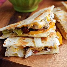 two quesadillas stacked on top of each other next to a green cup