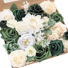 an open box filled with lots of white and green flowers