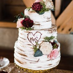 a wedding cake decorated with flowers and leaves