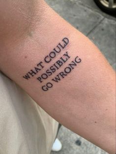 a person with a tattoo on their arm that says what could possibly go wrong?