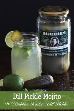 two jars filled with pickle mojito next to cucumbers