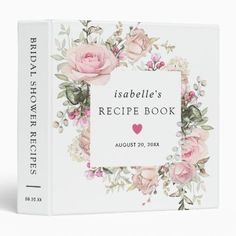 a recipe book with pink roses and greenery on the cover is shown in front of a white background