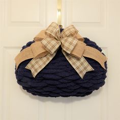 a blue rope wreath with a bow hanging on the front door to give it a festive touch