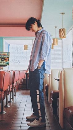 a man standing on top of a pair of shoes in a room filled with chairs