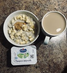 there is a bowl of oatmeal next to a cup of coffee