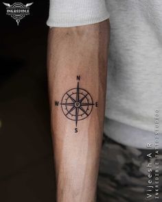 a man with a compass tattoo on his arm