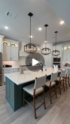 a large kitchen with an island in the middle and lots of chairs on top of it