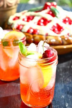 two glasses filled with drinks sitting on top of a table