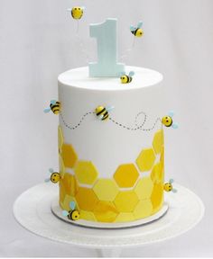 a birthday cake decorated with honeybees and the number one on it's top