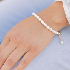 Dress up your wrist with this timeless white pearl beaded bracelet. Perfect for any special occasion, its simple yet elegant design adds a classic romantic touch to your outfit. With an adjustable chain, it fits comfortably any size wrist. Feel beautiful and sophisticated with this dainty and dreamy bracelet! ⬩3mm x4mm Natural Oval Freshwater Pearl⬩6-in bracelet with Gold Plated 2" chain for multiple closure options⬩Pearl is said to be associated with wisdom and romance This item will ship with Pearl White Adjustable Pearl Charm Bracelet, Elegant White Pearl Bracelet With Adjustable Chain, Adjustable Pearl White Bracelet With Pearl Drop, Adjustable Pearl Bracelet With Pearl Drop, Delicate Adjustable Pearl Bracelet, Dainty Adjustable Pearl Chain Bracelet, White Pearl Bracelet With Adjustable Chain, Dainty Adjustable Pearl Bracelet, Elegant White Beaded Bracelets With Adjustable Chain