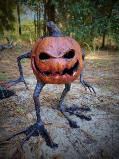 an odd looking pumpkin with its legs spread out and eyes wide open, standing in the dirt