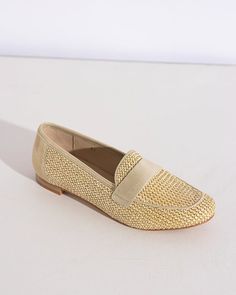 a woman's tan loafer shoe on a white surface