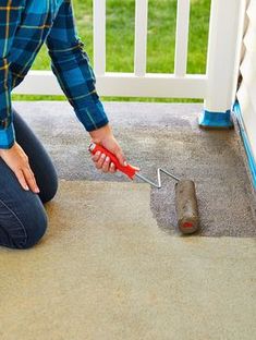 a woman kneeling down on the ground with a tool