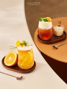 two glasses filled with drinks sitting on top of a wooden tray next to an orange slice