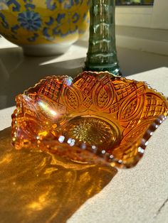 an orange glass bowl sitting on top of a table