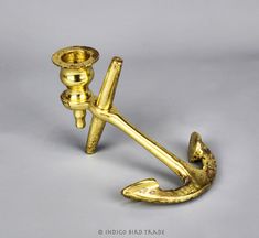 an antique brass anchor hook on a gray background