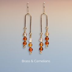 One pair of handmade earrings with 12 Carnelian stones (6mm) and small glass beads (1x2mm). These Earrings are shaped by hand and hardened by hammering to make it stronger and harder. Metal used is nickel safe Tarnish Resistant Brass - Artistic Wire®. The color of the stones can vary due to different lights and screens. ❀ ❀ ❀ Carnelian is said to be a stone of courage, endurance, energy, leadership and motivation. ❀ ❀ ❀ Take care of your earrings: - Avoid contact with moisture and chemicals (wat Adjustable Carnelian Earrings With Natural Stones, Handmade Adjustable Carnelian Earrings, Adjustable Carnelian Dangle Earrings, Carnelian Wire Wrapped Earrings For Gift, Carnelian Wire Wrapped Earrings As Gift, Gift Carnelian Wire Wrapped Earrings, Carnelian Dangle Jewelry For Pierced Ears, Heirloom Baby Blankets, Waterfall Earrings