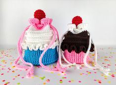 two crocheted purses sitting next to each other on top of a table