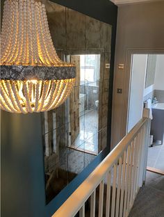 a chandelier hanging from the side of a stair case next to a door