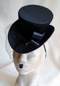 This burlesque style mini top hat is covered with fine black satin. It is embellished with black ribbon and a beautiful black and clear crystal button. The piece is completed with gorgeous black birdcage veil with clear sparkling rhinestones. Measurements : height 4 inches( 10 cm ) front to back 9 inches ( 22 cm ) side to side 7.5 inches ( 19 cm ) This mini top hat is fully lined with satin and attaches to the head with thin elastic that goes under the hair, to ensure stability and achieve that Ringmaster Hat, Black Birdcage Veils, Veil Black, Elizabethan Collar, Ladies Hat, Mini Top Hat, Birdcage Veil, Cocktail Hat, Crystal Buttons