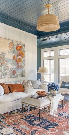 a living room filled with furniture and a painting on the wall above it's windows