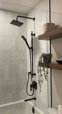 the shower head is attached to the wall above the bathtub, with shelves on either side