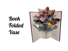 an open book with folded origami flowers on it and the words book folded vase