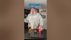 a man standing at a bar with two beers in front of him