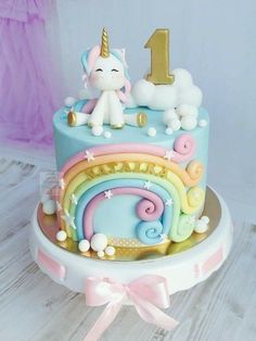 a birthday cake decorated with an unicorn and rainbow