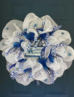 a blue and white mesh wreath hanging on the front door