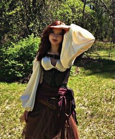 a woman wearing a brown and white dress with a hat on top of her head