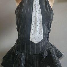 a mannequin wearing a black and white striped dress with a tie on it