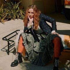 a woman sitting on top of a wooden bench