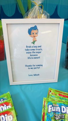 some candy bags are sitting on a table next to a picture frame with a quote