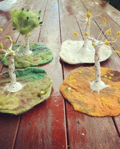 three small trees sitting on top of a wooden table