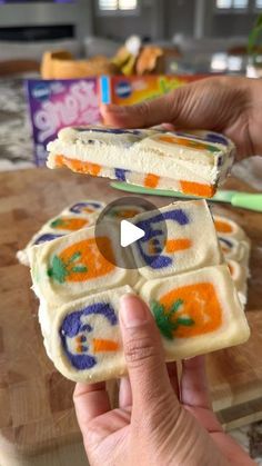 someone is holding up some food on a cutting board while another person uses a toothbrush to cut it