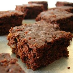 some brownies are sitting on a piece of parchment paper and ready to be eaten