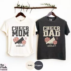 These trendy matching cheer mom and cheer dad shirts are perfect for cheerleader parents. This shirt has a distressed vintage look graphic personalized with name or multiple names if required. The shirt has a unisex fit. Please see the size chart and fit guide in the listing photos. 💗 Items are available for purchase separately. The price is for 1 shirt, purchase 2 shirts to make a set.  STYLE GUIDE * Comfort Colors® * Quality unisex crewneck tee * Relaxed fit with tubular body * Pre-shrunk & garment-dyed fabric for a soft vintage look & feel   MATERIAL *100% ethically grown ring-spun US cotton 👉 SIZE GUIDE You can find the size guide in the listing photos including measurements. Please check these before purchase and if in doubt, compare to one of your own comfortable fitting garments s Cheer Parent Shirts Design, Cheer Parent Shirts, Cheer Dad Shirt Ideas, Cheer Mom Shirt Ideas, Cheer Dad Shirt, Cheer Dad Shirts, Cheer Mom Shirt, Cheer Gear