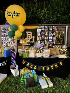 a birthday party with balloons and gifts on the grass in front of a sign that says payder