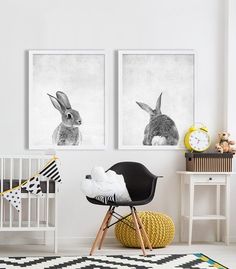 a room with two framed pictures and a chair in front of the crib has a stuffed rabbit on it