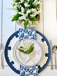 a blue and white place setting with flowers