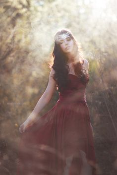 a woman in a red dress is posing for the camera with her hands on her hips