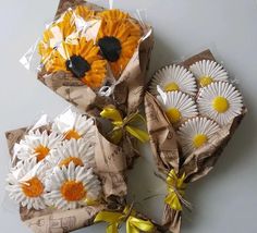 three bouquets of flowers wrapped in brown paper