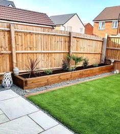 a backyard with grass and wooden fenced in area next to the yard is an artificial lawn