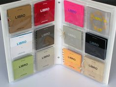 an open binder with several different types of books in it on a white surface